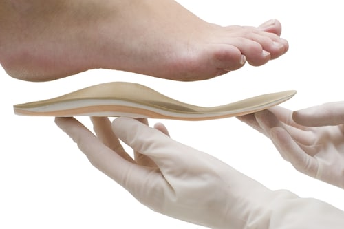 Image of an orthotic insoles being fitted to a patient