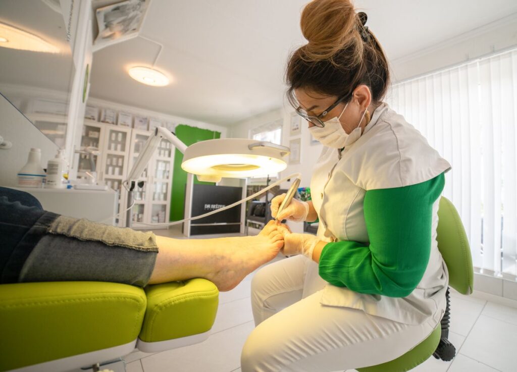 Podiatrist treating toenail fungus with clinical instruments in Sydney clinic